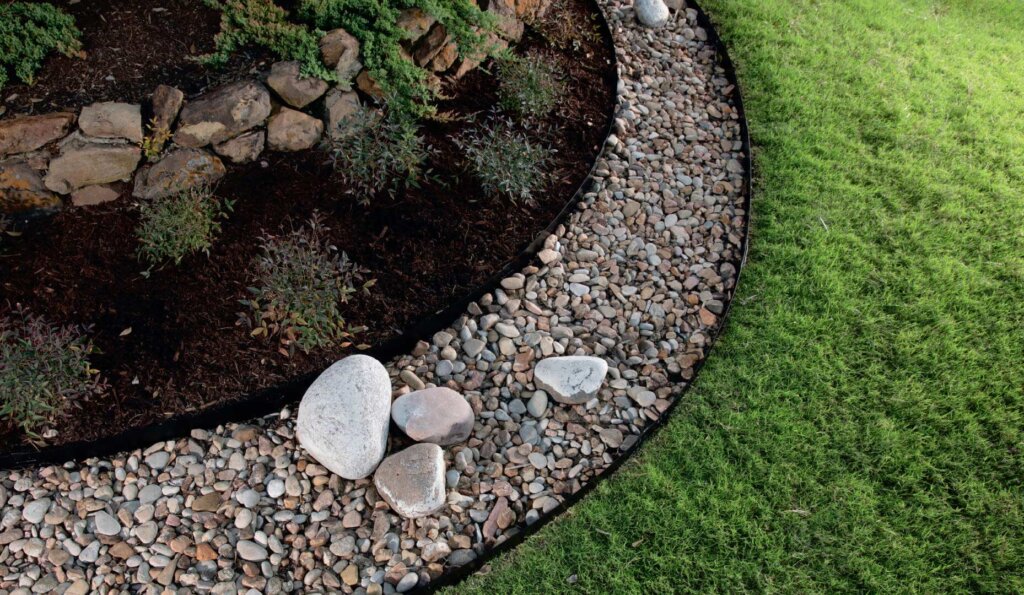 attached-stake edging used along different sections of garden with grass, rocks, and plants
